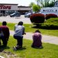 FILE - People pray outside the scene of a shooting where police are responding at a supermarket, in Buffalo, N.Y., May 15, 2022. When police confronted Payton Gendron, the white man suspected of killing 10 Black people at the supermarket, he had an AR-15-style rifle and was cloaked in body armor. Yet officers talked to Gendron, convinced him to put down his weapon and arrested him without firing a single shot. Some people are asking why that type of treatment hasn&#39;t been afforded to Black people in encounters where they were killed over minor traffic infractions, or no infractions at all. (AP Photo/Matt Rourke, File)