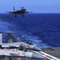 In this photo released Dec. 31, 2021, by Xinhua News Agency, an undated photo shows a carrier-based J-15 fighter jet preparing to land on the Chinese navy&#39;s Liaoning aircraft-carrier during open-sea combat training. China is holding military exercises in the disputed South China Sea coinciding with U.S. President Joe Biden&#39;s visits to South Korea and Japan that are largely focused on countering the perceived threat from China. (Hu Shanmin/Xinhua via AP)