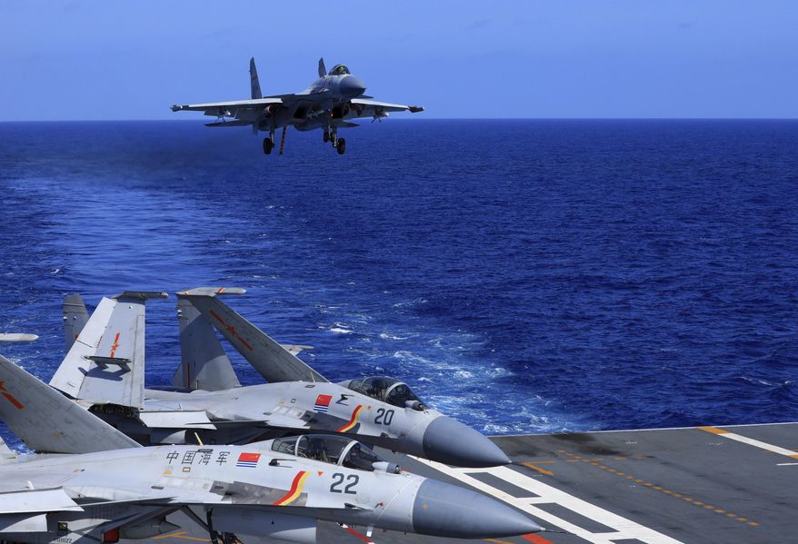 In this photo released Dec. 31, 2021, by Xinhua News Agency, an undated photo shows a carrier-based J-15 fighter jet preparing to land on the Chinese navy&#x27;s Liaoning aircraft carrier during open-sea combat training. China is holding military exercises in the disputed South China Sea coinciding with U.S. President Joe Biden&#x27;s visits to South Korea and Japan that are largely focused on countering the perceived threat from China. (Hu Shanmin/Xinhua via AP) ** FILE **