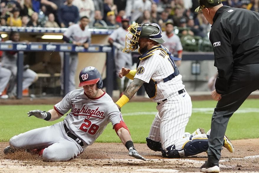 Milwaukee Brewers catcher Omar Narvaez tags out Washington Nationals&#39; Lane Thomas at home during the seventh inning of a baseball game Friday, May 20, 2022, in Milwaukee. Thomas tried to stretch a triple into an inside the park home run. (AP Photo/Morry Gash)