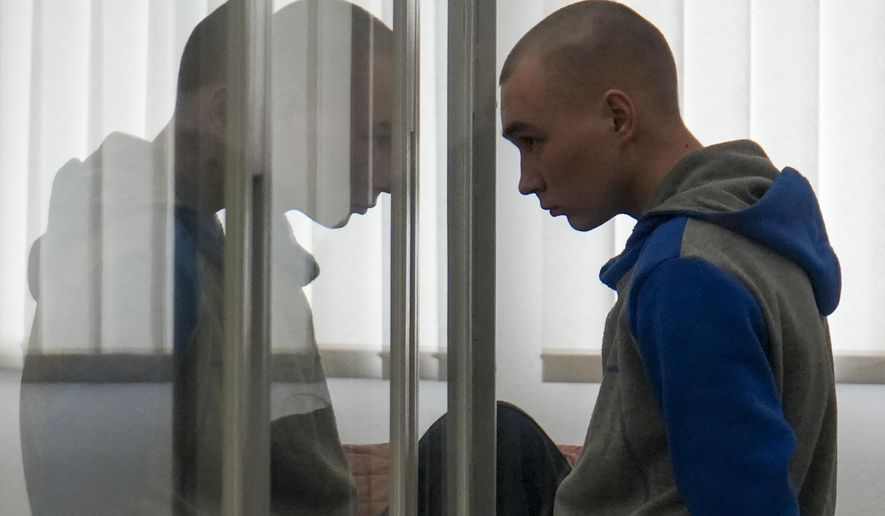 Russian Sgt. Vadim Shishimarin stands in court during a hearing in Kyiv, Ukraine, Thursday, May 19, 2022. The 21 year old Russian soldier facing the first war crimes trial since the start of the war in Ukraine testified Thursday that he shot a civilian on orders from two officers and pleaded for his victim&#39;s widow to forgive him. (AP Photo/Roman Hrytsyna)