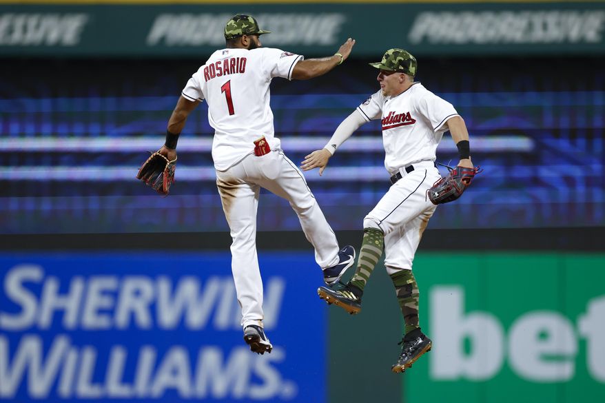 Cleveland Guardians&#39; Amed Rosario (1) and Myles Straw celebrate a win over the Detroit Tigers in a baseball game, Friday, May 20, 2022, in Cleveland. (AP Photo/Ron Schwane)