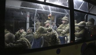 Ukrainian servicemen sit in a bus after leaving Mariupol&#39;s besieged Azovstal steel plant, near a penal colony, in Olyonivka, in territory under the government of the Donetsk People&#39;s Republic, eastern Ukraine, Friday, May 20, 2022. (AP Photo)