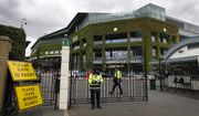 FILE - Security guards are shown at the gate in front of Centre Court at the All England Lawn Tennis Club, after the 2020 tennis championships were canceled due to the coronavirus, in Wimbledon, London, Monday, June 29, 2020. The ATP men’s professional tennis tour will not award ranking points for Wimbledon this year because of the All England Club’s ban on players from Russia and Belarus over the invasion of Ukraine. The ATP announced its decision Friday night, May 20, 2022, two days before the start of the French Open — and a little more than a month before play begins at Wimbledon on June 27. It is a highly unusual and significant rebuke of the oldest Grand Slam tournament.  (AP Photo/Kirsty Wigglesworth, File)