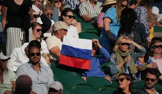 FILE - A spectator holding a Russian flag watches during the men&#39;s singles third round match between Russia&#39;s Daniil Medvedev and Croatia&#39;s Marin Cilic on day six of the Wimbledon Tennis Championships in London, Saturday July 3, 2021. The ATP men’s professional tennis tour will not award ranking points for Wimbledon this year because of the All England Club’s ban on players from Russia and Belarus over the invasion of Ukraine. The ATP announced its decision Friday night, May 20, 2022, two days before the start of the French Open — and a little more than a month before play begins at Wimbledon on June 27. It is a highly unusual and significant rebuke of the oldest Grand Slam tournament. (AP Photo/Alberto Pezzali, File)