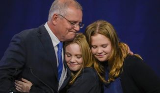 Australian Prime Minister Scott Morrison hugs his daughters Lily and Abbey at a Liberal Party function in Sydney, Australia, Saturday, May 21, 2022. Morrison has conceded defeat and has confirmed that he would hand over the leadership of the Liberal Party following his party&#39;s loss to Labor in today&#39;s federal election. (AP Photo/Mark Baker)