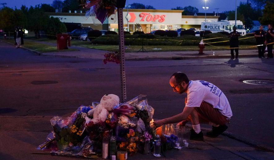 FILE - A person pays his respects at a makeshift memorial outside the scene of a shooting at a supermarket in Buffalo, N.Y., Sunday, May 15, 2022. (AP Photo/Matt Rourke, File)