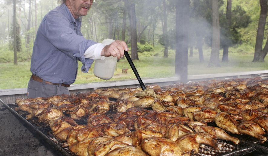 David Tribbitt bastes some chicken  at the Milford Moose 2316&#39;s opening day for its chicken barbecue season on Saturday, May 14, 2022 in Milford, Del.. (Logan B. Anderson/Delaware State News via AP)