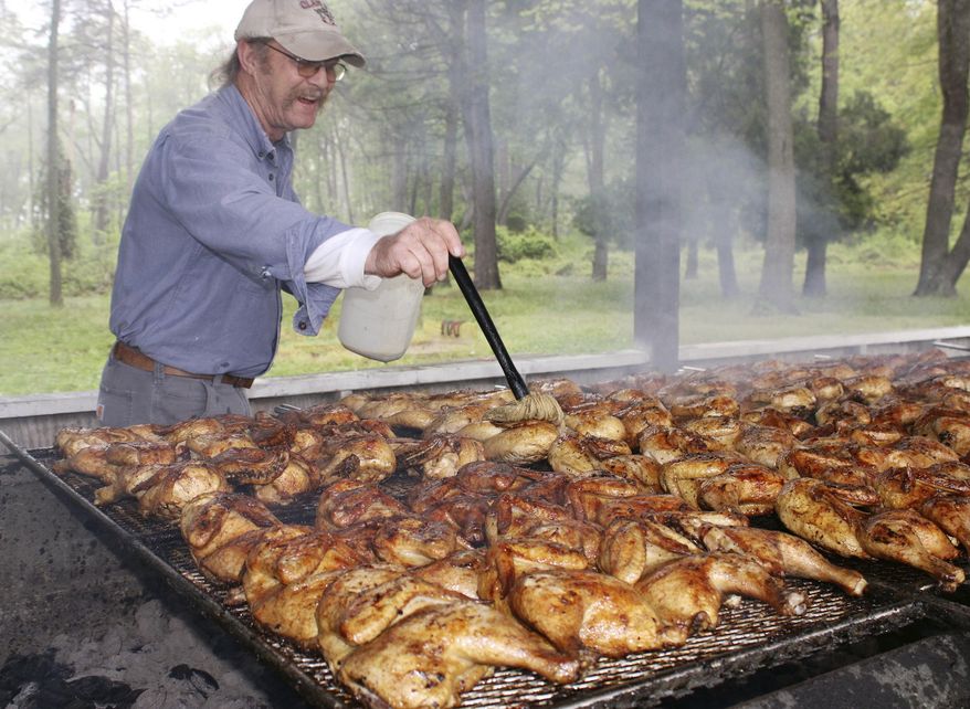 David Tribbitt bastes some chicken  at the Milford Moose 2316&#39;s opening day for its chicken barbecue season on Saturday, May 14, 2022 in Milford, Del.. (Logan B. Anderson/Delaware State News via AP)