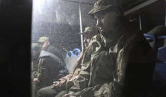 Ukrainian servicemen sit in a bus after they left the besieged Mariupol&#39;s Azovstal steel plant, near a penal colony in Olyonivka, in territory under the government of the Donetsk People&#39;s Republic, eastern Ukraine, Friday, May 20, 2022. (AP Photo)