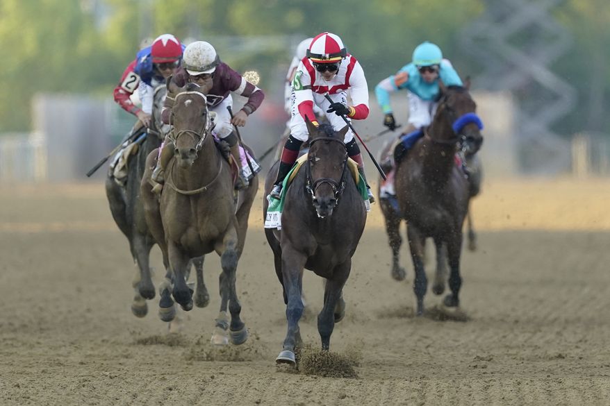 Jose Ortiz, second from right, atop Early Voting, heads to the finish line while winning the 147th running of the Preakness Stakes horse race at Pimlico Race Course, Saturday, May 21, 2022, in Baltimore. (AP Photo/Nick Wass) **FILE**
