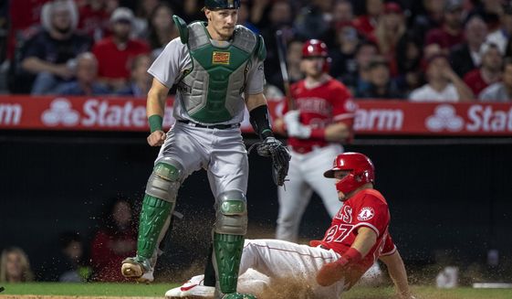 Los Angeles Angels&#39; Mike Trout scores without a throw to Oakland Athletics catcher Sean Murphy, left, on an infield hit by Luis Rengifo during the sixth inning of a baseball game in Anaheim, Calif., Saturday, May 21, 2022. (AP Photo/Alex Gallardo)