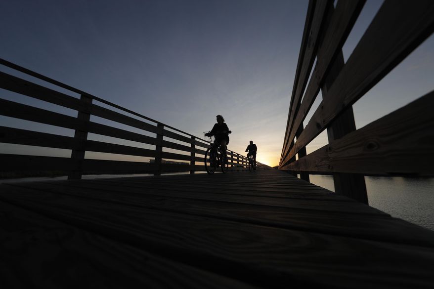 Bike riders cross over a boardwalk at Gulf State Park in Gulf Shores, Ala., in this file photo from March 12, 2020. Alabama voters on Tuesday, May 24, 2022, will consider a constitutional amendment that would provide $85 million for improvements to state parks and historical sites. (AP Photo/Gerald Herbert, File)