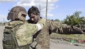 In this photo taken from video released by the Russian Defense Ministry on Friday, May 20, 2022, a Russian serviceman frisks a Ukrainian serviceman after they leaved the besieged Azovstal steel plant in Mariupol, in territory under the government of the Donetsk People&#39;s Republic, eastern Ukraine. (Russian Defense Ministry Press Service via AP)