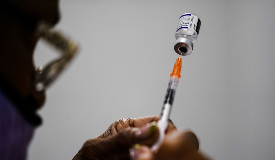 A syringe is prepared with the Pfizer COVID-19 vaccine at a vaccination clinic at the Keystone First Wellness Center in Chester, Pa., Dec. 15, 2021. A federal appeals court is being asked Monday, May 23, 2022, to reconsider its decision allowing the Biden administration to require federal employees to get vaccinated against COVID-19. (AP Photo/Matt Rourke, File)
