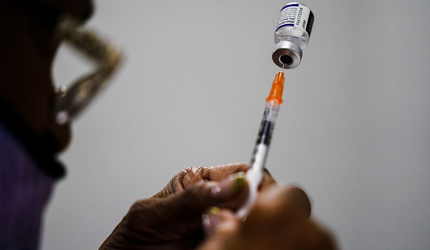 A syringe is prepared with the Pfizer COVID-19 vaccine at a vaccination clinic at the Keystone First Wellness Center in Chester, Pa., Dec. 15, 2021. A federal appeals court is being asked Monday, May 23, 2022, to reconsider its decision allowing the Biden administration to require federal employees to get vaccinated against COVID-19. (AP Photo/Matt Rourke, File)