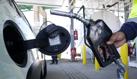 A worker fills up the tank of a new car at the Boston Autoport terminal along the Charlestown waterfront, Tuesday, May 24, 2022, in Boston. (AP Photo/Charles Krupa)
