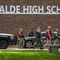 Law enforcement personnel walk outside Uvalde High School after shooting a was reported earlier in the day at Robb Elementary School, Tuesday, May 24, 2022, in Uvalde, Texas. (William Luther/The San Antonio Express-News via AP)