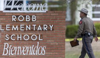 A state trooper walks past the Robb Elementary School sign in Uvalde, Texas, Tuesday, May 24, 2022, following a deadly shooting at the school. (William Luther/The San Antonio Express-News via AP)