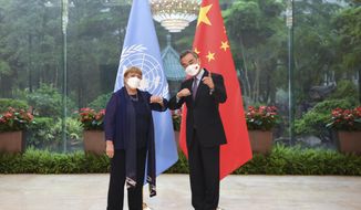 In this photo released by Xinhua News Agency, Chinese Foreign Minister Wang Yi, right, meets with the United Nations High Commissioner for Human Rights Michelle Bachelet in Guangzhou, southern China&#39;s Guangdong Province on Monday, May 23, 2022. (Deng Hua/Xinhua via AP)