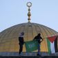 FILE - Masked Palestinians carry Palestinian and Hamas flags during Eid al-Fitr celebrations next to the next to the Dome of the Rock Mosque in the Al-Aqsa Mosque compound in the Old City of Jerusalem on May 2, 2022. Israeli authorities said Tuesday, May 24, they have foiled a wide-ranging plot by Hamas militants to shoot a member of parliament, kidnap soldiers and bomb Jerusalem&#39;s light rail system during a surge of violence that has left dozens dead in recent weeks. (AP Photo/Mahmoud Illean, File)