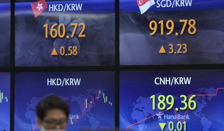 A currency trader stands near the screens showing the foreign exchange rates at a foreign exchange dealing room in Seoul, South Korea, Wednesday, May 25, 2022. Asian stock markets were mixed Wednesday after Wall Street sank on weak U.S. housing sales and a profit warning by a prominent social media brand. (AP Photo/Lee Jin-man)