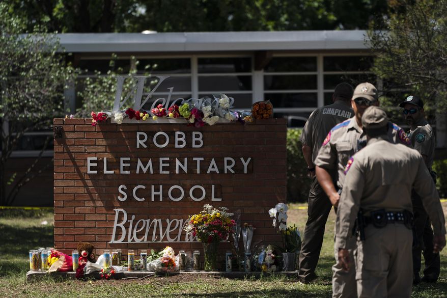 Flowers and candles are placed outside Robb Elementary School in Uvalde, Texas, Wednesday, May 25, 2022, to honor the victims killed in Tuesday&#39;s shooting at the school. Desperation turned to heart-wrenching sorrow for families of grade schoolers killed after an 18-year-old gunman barricaded himself in their Texas classroom and began shooting, killing several fourth-graders and their teachers. (AP Photo/Jae C. Hong)