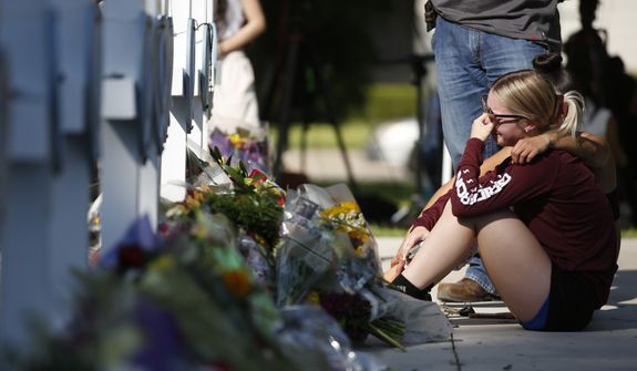 A woman reacts as she pays her respects at a memorial site for the victims killed in this week&#39;s elementary school shooting in Uvalde, Texas, Thursday, May 26, 2022. (AP Photo/Dario Lopez-Mills)