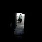 Dina walks out of her home ruined by shelling in Horenka, on the outskirts Kyiv, Ukraine, Wednesday, May 25, 2022. (AP Photo/Natacha Pisarenko)