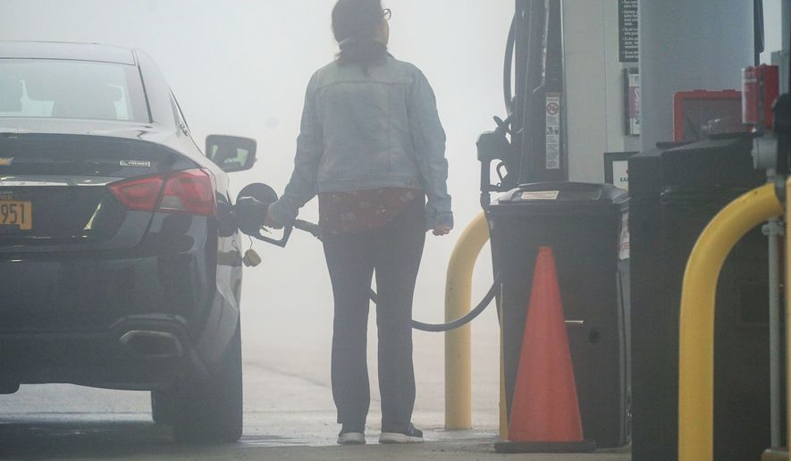 A motorist fills up the tank of a car ahead of the Memorial Day holiday weekend, on a foggy morning at the Hickory Run Service Plaza in Jim Thorpe, Pa., Friday, May 27, 2022. (AP Photo/Matt Rourke)