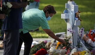 A woman pays her respects at a memorial site for the victims killed in this week&#39;s shooting at Robb Elementary School in Uvalde, Texas, Friday, May 27, 2022. (AP Photo/Dario Lopez-Mills)