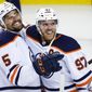 Edmonton Oilers center Connor McDavid, right, celebrates his goal against the Calgary Flames with defenseman Cody Ceci in overtime in Game 5 of an NHL hockey second-round playoff series Thursday, May 26, 2022, in Calgary, Alberta. (Jeff McIntosh/The Canadian Press via AP)