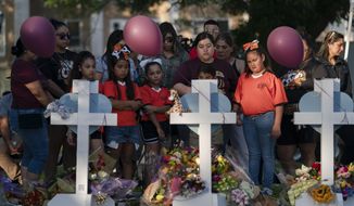 People gather at a memorial site to pay their respects for the victims killed in this week&#39;s elementary school shooting in Uvalde, Texas, Thursday, May 26, 2022. (AP Photo/Jae C. Hong)