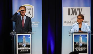 Los Angeles City Attorney Mike Feuer, left, and U.S. Rep. Karen Bass get ready at the start of a mayoral debate at the Student Union Theater on the California State University, Los Angeles campus on Sunday, May 1, 2022. (Ringo Chiu/Los Angeles Times via AP)
