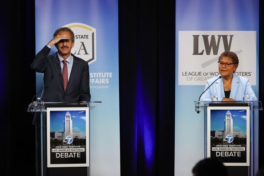 Los Angeles City Attorney Mike Feuer, left, and U.S. Rep. Karen Bass get ready at the start of a mayoral debate at the Student Union Theater on the California State University, Los Angeles campus on Sunday, May 1, 2022. (Ringo Chiu/Los Angeles Times via AP)