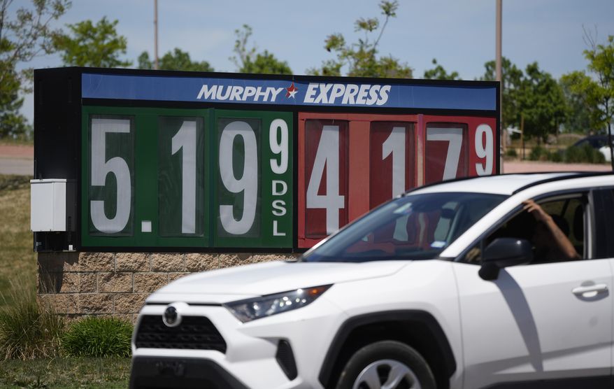 Gasoline prices are displayed outside a convenience store as a motorist drives by on Thursday, May 26, 2022, in Thornton, Colo. Experts are expecting a flush of travelers at airports and on the nation&#39;s byways during the long Memorial Day weekend, which marks the start of the summer travel season, in spite of high fuel costs. (AP Photo/David Zalubowski)