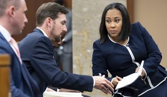 Fulton County District Attorney Fani Willis, right, talks with a member of her team during proceedings to seat a special purpose grand jury in Fulton County, Georgia, on Monday, May 2, 2022, to look into the actions of former President Donald Trump and his supporters who tried to overturn the results of the 2020 election. The hearing took place in Atlanta. (AP Photo/Ben Gray)