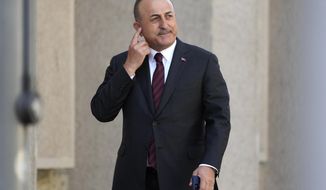Turkish Foreign Minister Mevlut Cavusoglu scratches his head during an informal meeting of the North Atlantic Council in Foreign Ministers&#39; session in Berlin, Germany, Sunday, May 15, 2022. (AP Photo/Michael Sohn)