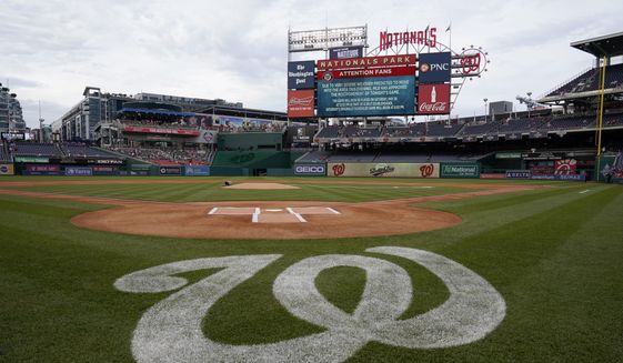 A message on the outfield screen announces the postponement of a baseball game between the Colorado Rockies and the Washington Nationals due to inclement weather, Friday, May 27, 2022, in Washington. The game was rescheduled for Saturday. (AP Photo/Patrick Semansky)