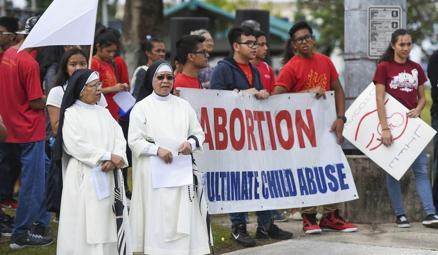 In this Jan. 22, 2017, photo, the Guam Catholic Pro-Life Committee holds its annual &amp;quot;Chain for Life&amp;quot; protest against abortion at the Guam International Trade Center intersection in Tamuning, Guam. Women from the remote U.S. territories of Guam and the Northern Mariana Islands will likely have to travel farther than other Americans to terminate a pregnancy if the Supreme Court overturns a precedent that established a national right to abortion in the United States. (Frank San Nicolas/The Pacific Daily via AP, File)