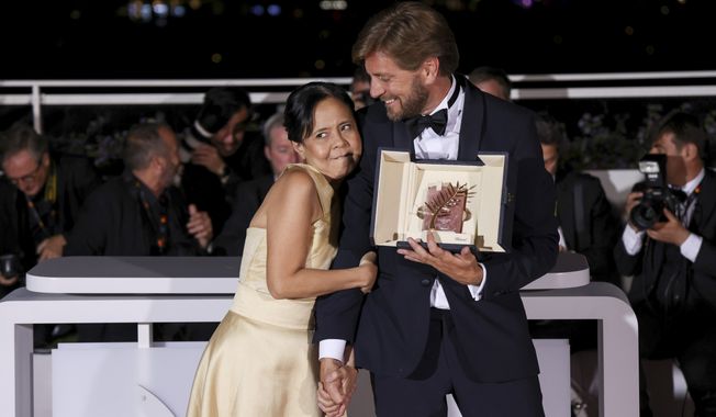 Writer/director Ruben Ostlund, winner of the Palme d&#x27;Or for &#x27;Triangle of Sadness,&#x27; poses with Dolly De Leon, left during the photo call following the awards ceremony at the 75th international film festival, Cannes, southern France, Saturday, May 28, 2022. (Photo by Vianney Le Caer/Invision/AP)