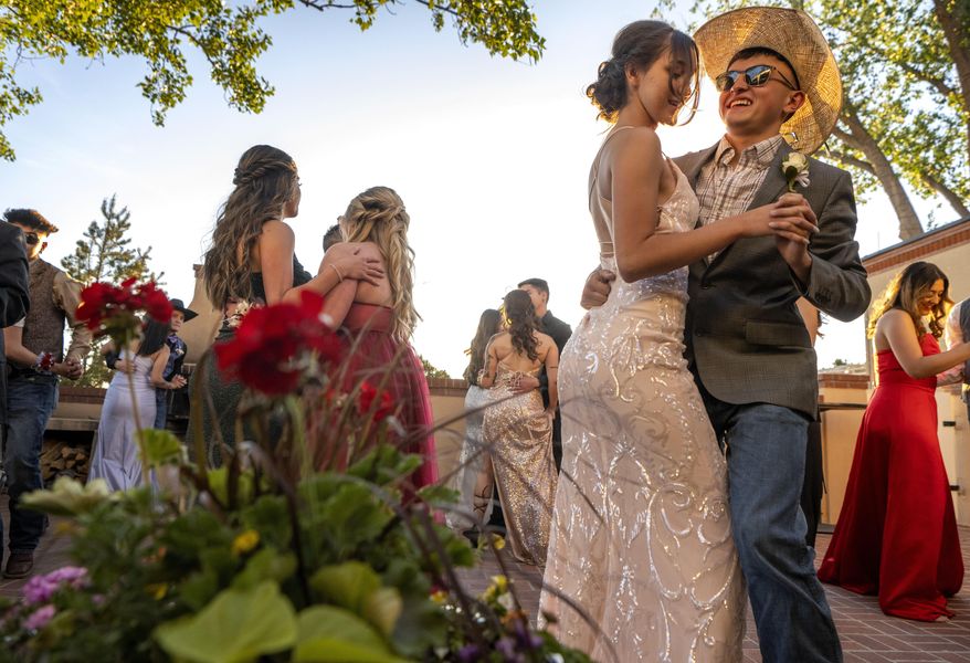 Maricela MacAuley, 17, and Adam Torres, 18, a senior at Mora High School, dance at the Governor's Mansion, Thursday May 26, 2022, in Santa Fe, N.M. Mora and communities around it have been evacuated in recent weeks because of the Calf Canyon/Hermits Peak Fire burning in the area and were unable to hold the prom in Mora. (Eddie Moore/The Albuquerque Journal via AP)