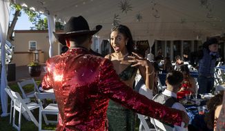 Sierra Velarde, 17, a junior, and Danta Alcon, 16, a sophomore at Mora High School, attend the school&#39;s prom held at the Governor&#39;s residence in Santa Fe, N.M., Thursday, May 26, 2022. Mora and communities around it have been evacuated in recent weeks because of the Calf Canyon/Hermits Peak Fire burning in the area and were unable to hold the prom in Mora. (Eddie Moore/The Albuquerque Journal via AP)