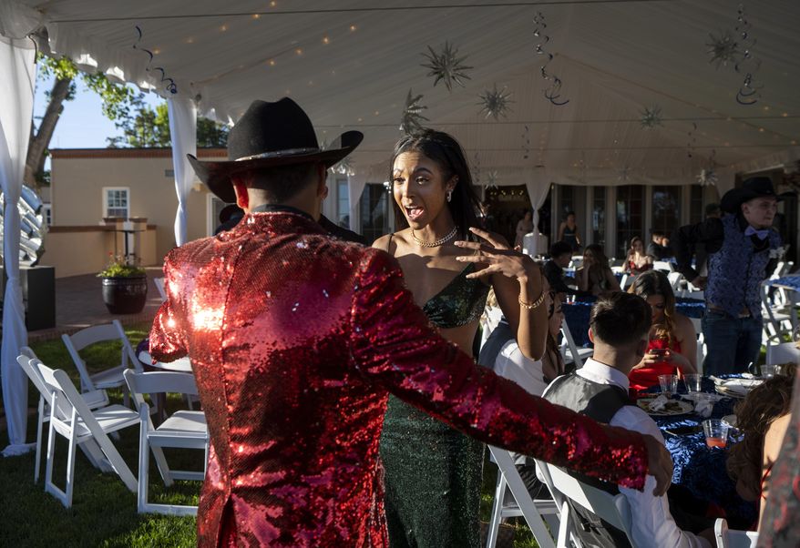 Sierra Velarde, 17, a junior, and Danta Alcon, 16, a sophomore at Mora High School, attend the school&#39;s prom held at the Governor&#39;s residence in Santa Fe, N.M., Thursday, May 26, 2022. Mora and communities around it have been evacuated in recent weeks because of the Calf Canyon/Hermits Peak Fire burning in the area and were unable to hold the prom in Mora. (Eddie Moore/The Albuquerque Journal via AP)