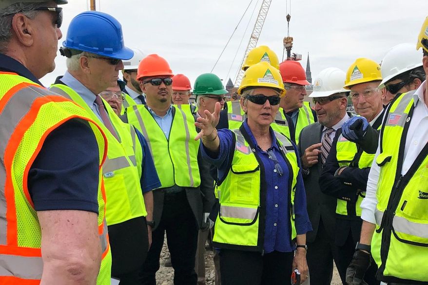 U.S. Energy Secretary Jennifer Granholm, center, tours the New London State Pier facility Friday, May 20, 2022 to view progress on a hub for the offshore wind power industry in New London, Conn. The U.S. energy secretary and Danish wind developer Orsted say they want American union workers to build offshore wind farms to dot the U.S. coastlines— the building trades workers who could otherwise be left out of the transition to relying more on renewable resources to reduce greenhouse gas emissions. (AP Photo/Jennifer McDermott)