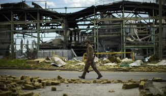 A Ukrainian serviceman walks past a gypsum manufacturing plant destroyed in a Russian bombing in Bakhmut, eastern Ukraine, eastern Ukraine, Saturday, May 28, 2022. Fighting has raged around Lysychansk and neighbouring Sievierodonetsk, the last major cities under Ukrainian control in Luhansk region. (AP Photo/Francisco Seco)
