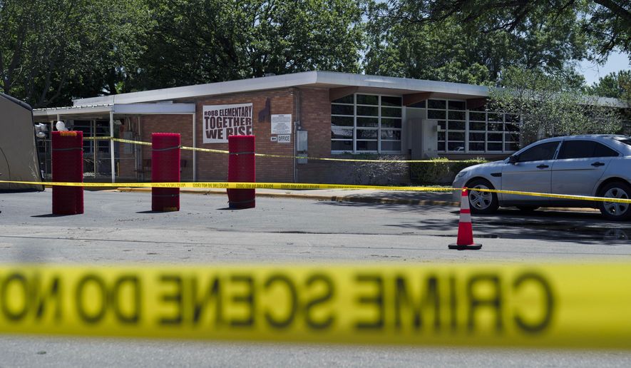 Crime scene tape surrounds Robb Elementary School in Uvalde, Texas, May 25, 2022. When the gunman arrived at the school, he hopped its fence and easily entered through an unlocked back door, police said. He holed himself up in a fourth-grade classroom where he killed the children and teachers. (AP Photo/Jae C. Hong, File)