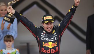 Red Bull driver Sergio Perez of Mexico celebrates on the podium after winning the Monaco Formula One Grand Prix, at the Monaco racetrack, in Monaco, Sunday, May 29, 2022. (AP Photo/Daniel Cole)
