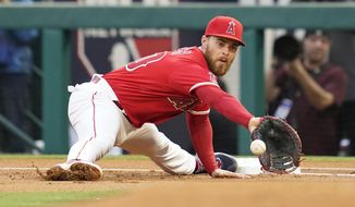 Los Angeles Angels first baseman Jared Walsh (20) catches a throw to first to out Toronto Blue Jays&#x27; Santiago Espinal (5) during the first inning of a baseball game in Anaheim, Calif., Saturday, May 28, 2022. (AP Photo/Ashley Landis)