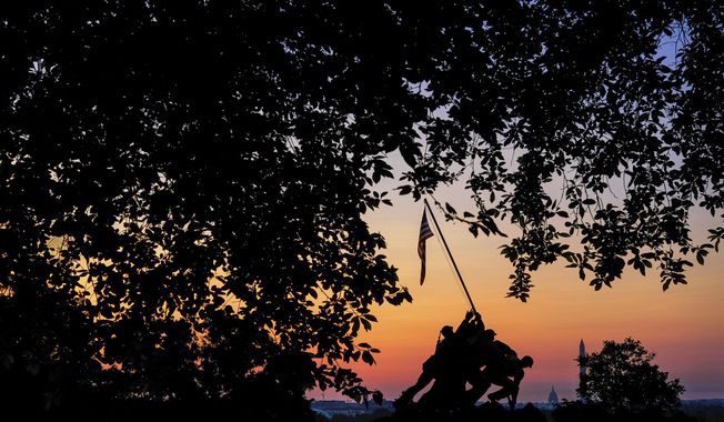 Sunrise silhouettes the US Marine Corps War Memorial in Arlington, Va., early in the morning on Memorial Day, Monday, May 30, 2022. (AP Photo/J. David Ake)
